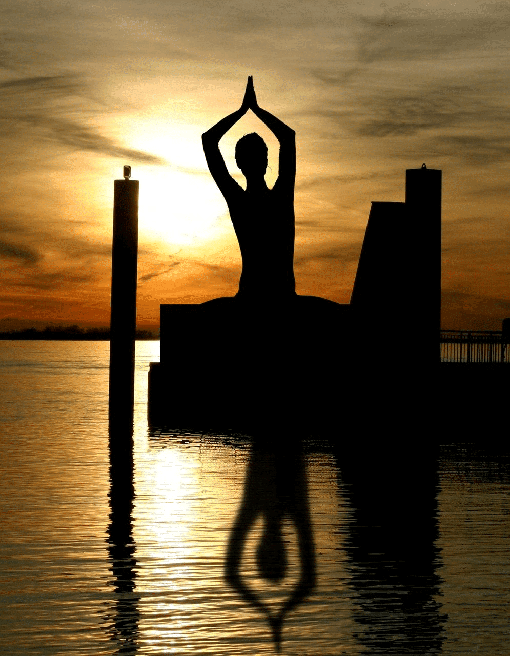 silhouette Frau yoga übung am Wasser vor Sonnenuntergang schatten