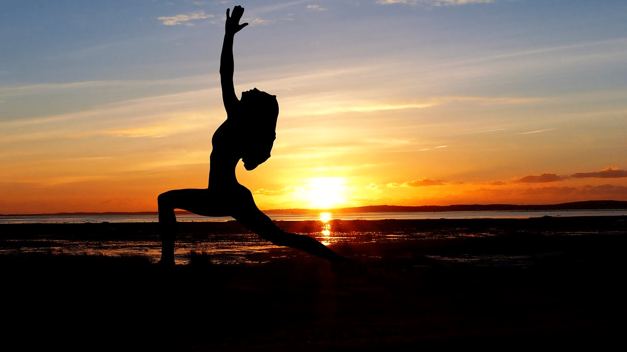 Yoga position Yogaübung Silhouette Frau am Strand vor Sonnenuntergang