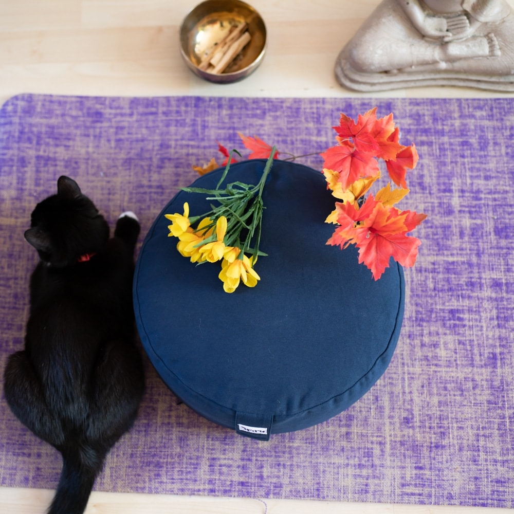 Ashtanga yoga bolster kissen blau auf Lila matte mit Blumen und Katze