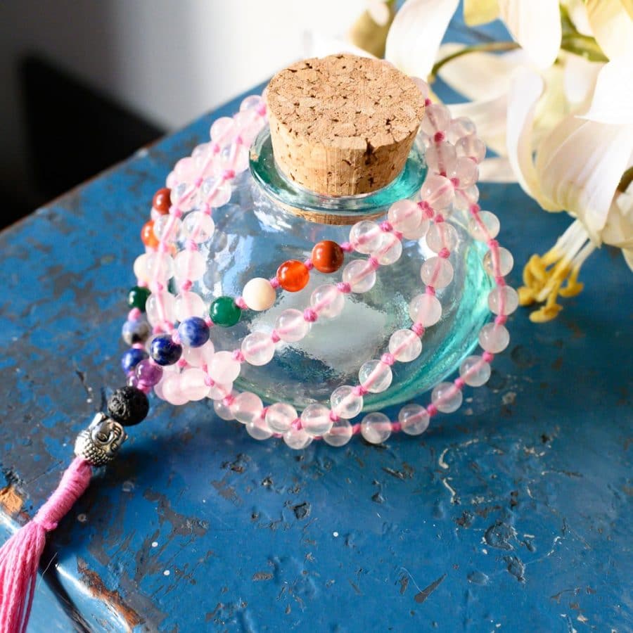 Glasflasche Mala Kette bunt auf blauem Schrank mit Blumen