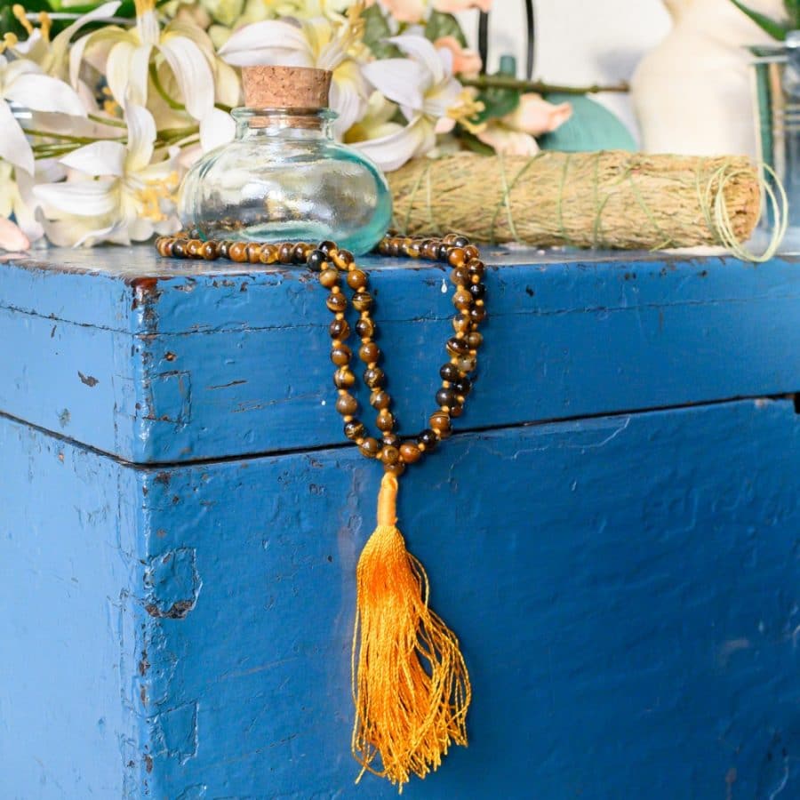 Glasflasche Mala Kette braun auf blauem Schrank mit Blumen