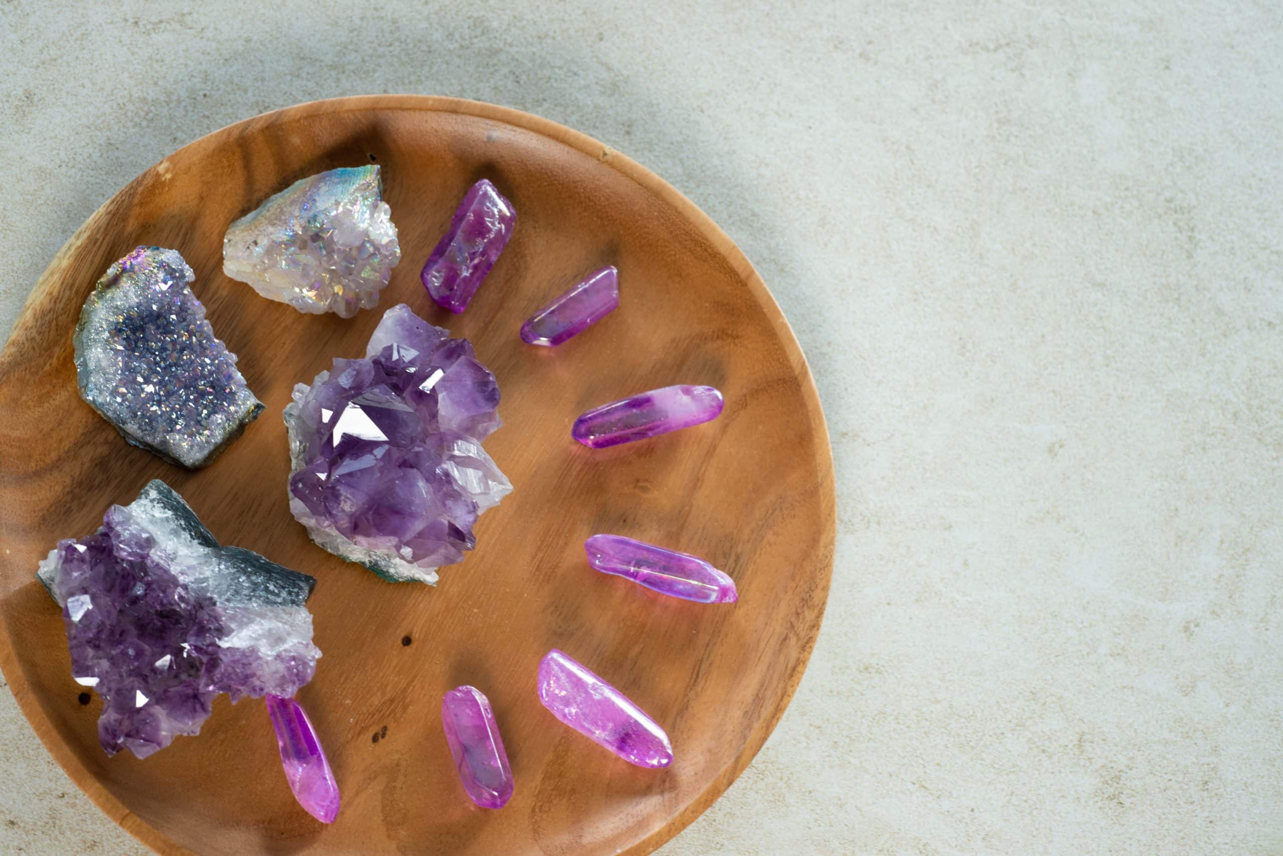 ungeschliffene Edelsteine mit Spitzen auf einer hölzernen Schale Amethyst Bergkristall Engelquarz